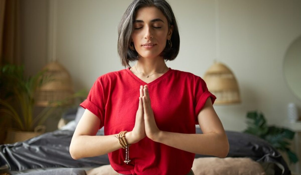 attractive-young-woman-having-premature-graying-meditating-home-with-eyes-closed-focusing-breathing-feeling-present-moment-making-namaste-gesture_343059-2111