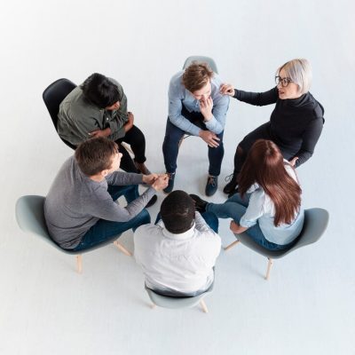 top-view-rehab-patients-standing-circle-talking_23-2148398227